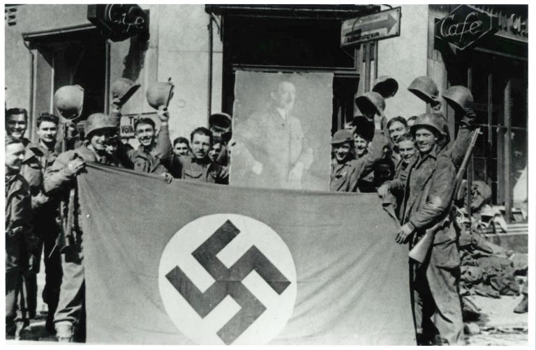 Spojenečtí vojáci s ukořistěnou vlajkou a obrazem führera.