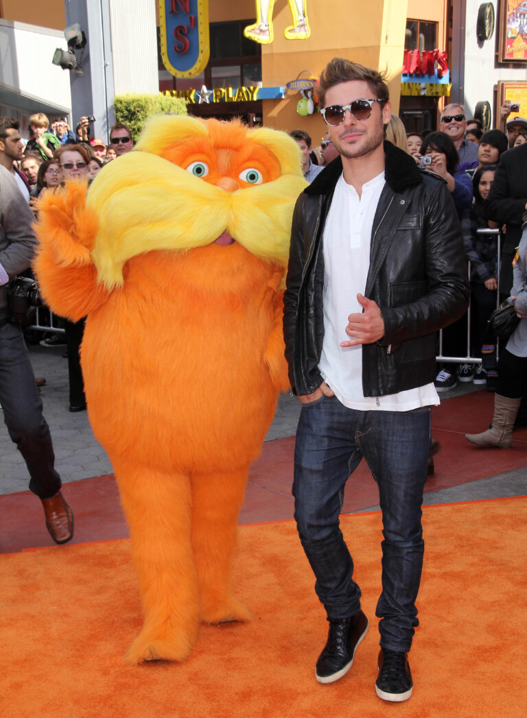 Zac Efron se usmívá po boku maskota, aniž by tušil, jakou nešťastnou publicitu zanedlouho získá.