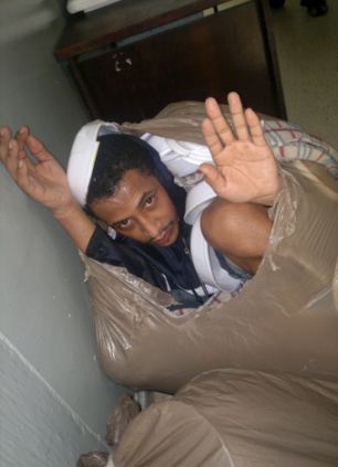 Detailní fotografie vězně v odpadním pytli.