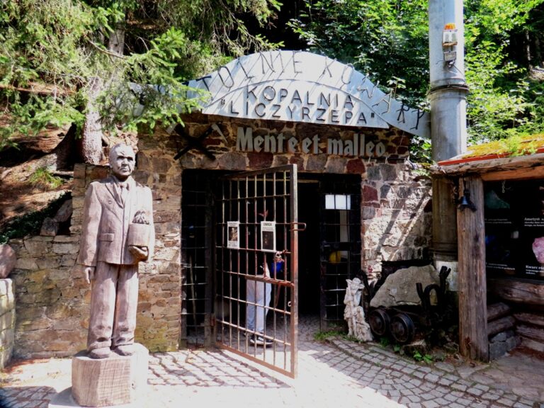 Vstup do uranového dolu. Nad vchodem je nápis Mente et malleo – Myslí a kladivem. Jde o latinské motto spojované s geologií i hornictvím.