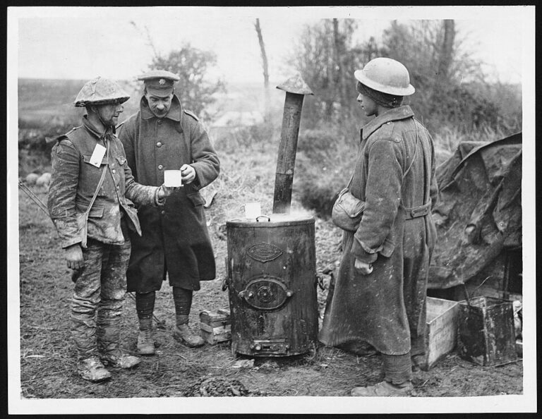 Člen britského armádního zdravotnického sboru podává šálek horké kávy zraněnému vojákovi u polních kamen na západní frontě, cca 1918.