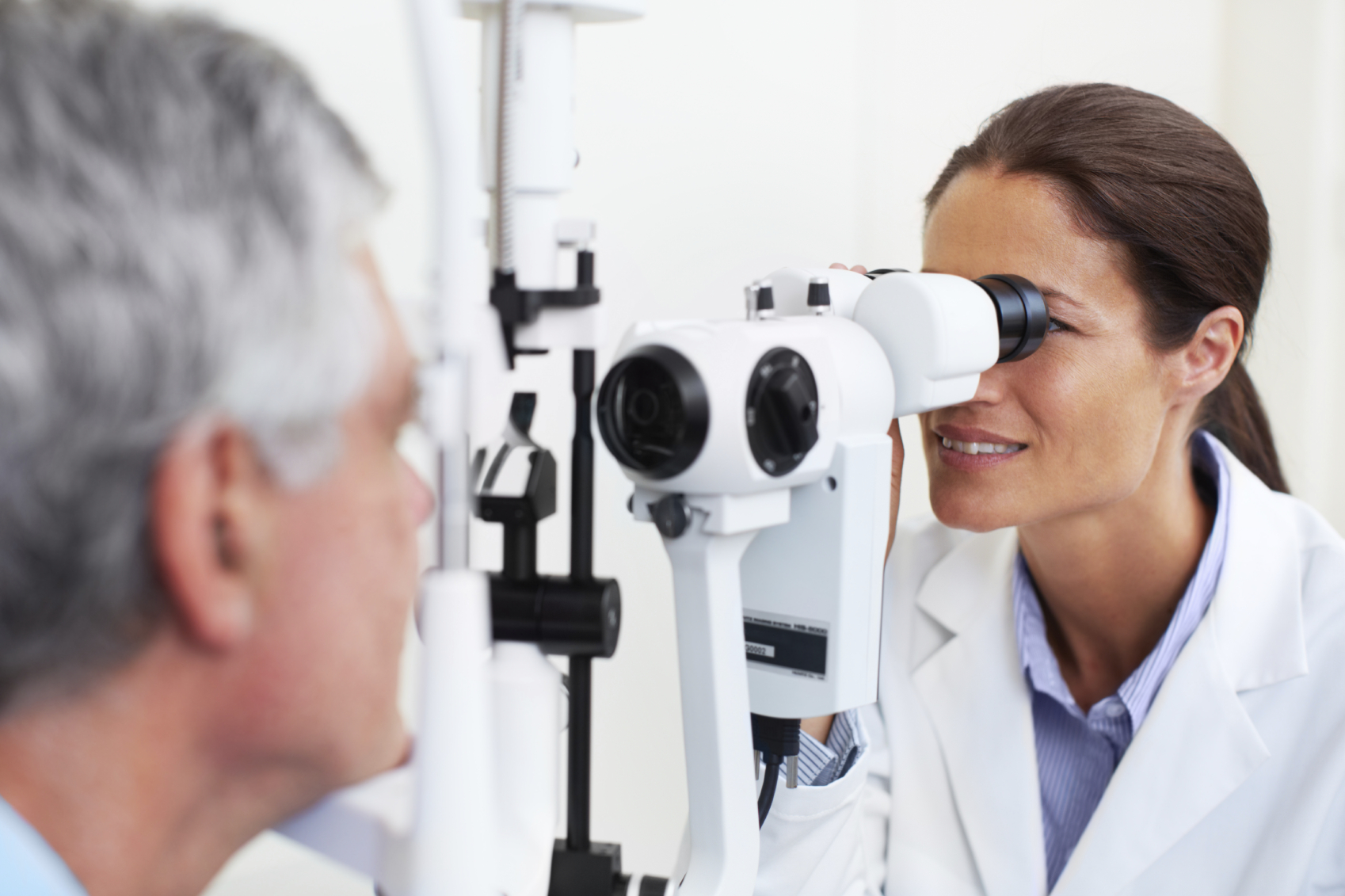 An ophthalmologist examining her patient's eyes with the help of a microbioscope