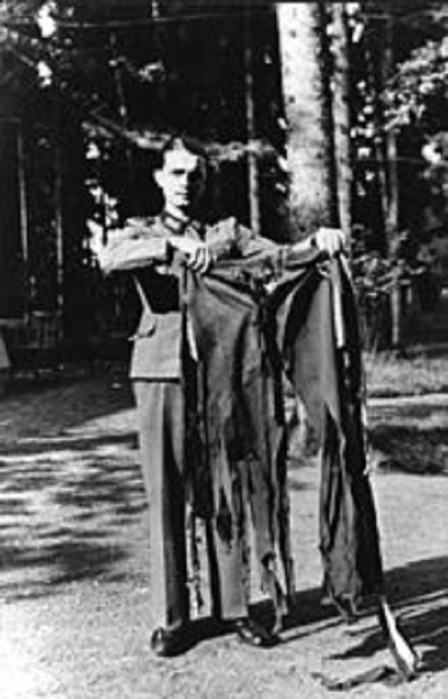 Voják ukazuje proděravěné kalhoty, které měl nacistický diktátor v okamžiku výbuchu na sobě. Co Hitlerovi zachránilo život?