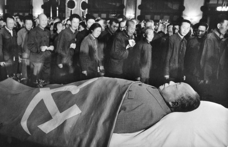 Den pohřbu předcházel horečný závod s časem, smrtí a formaldehydem. Rozstříhaný oblek byl zakryt státní vlajkou.