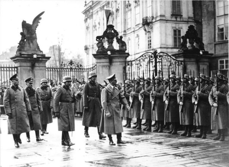 Slavnostní přehlídka na Pražském Hradě 16. března 1939 pod dozorem nacistického vůdce. Okupační jednotky defilují.