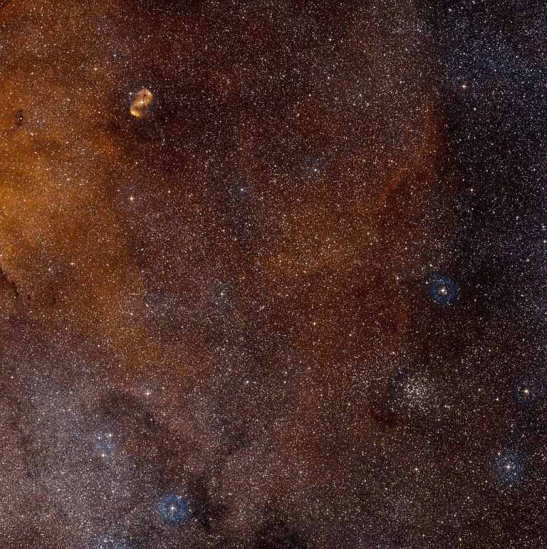 Tento širokoúhlý pohled zachycuje oblast oblohy v jižním souhvězdí Pravítka. Uprostřed se nachází mohutná oblast hvězdotvorby SDC 335.579-0.292, která je však příliš zastíněna prachem, než aby bylo možné ji ve viditelném světle .