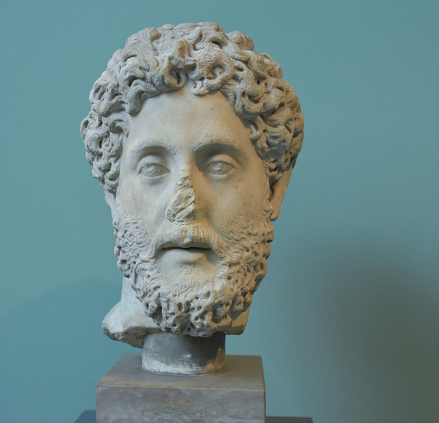 Commodus přikáže výměnu hlavy sochy za tu svoji.