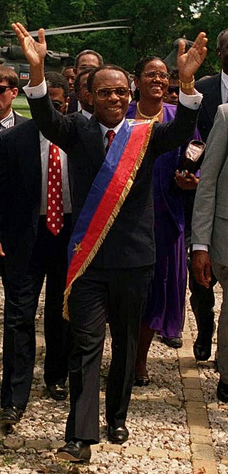 Haitský prezident Jean Bertrand Aristide povoluje kult woodoo.