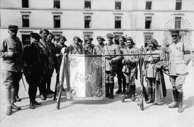 Čechoslováci před kasárnami ve francouzské Reuilly se zástavou. V bojích u Arrasu však o ni přijdou.