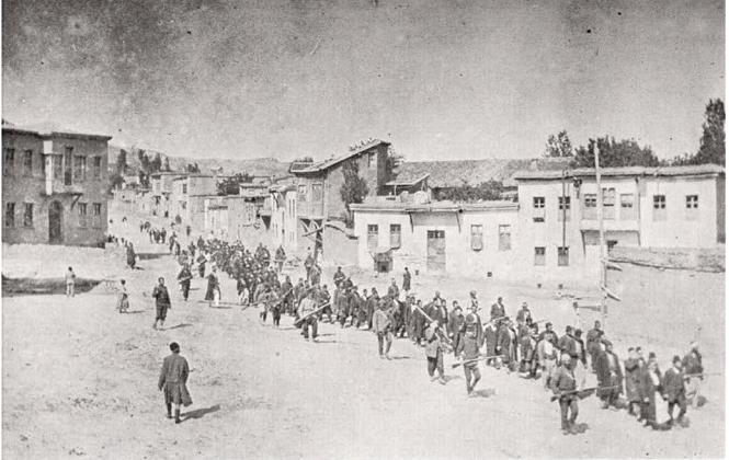 Arménští civilisté pochodují do jedné z osmanských věznic. Hlídají je turečtí vojáci.