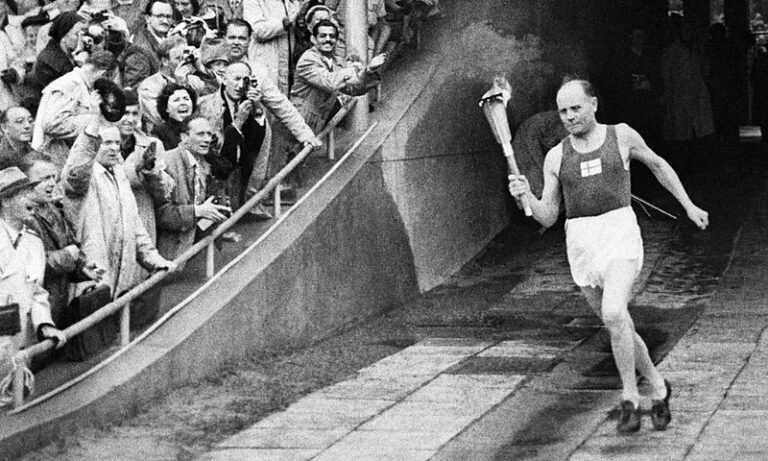 Olympijskou pochodeň v Helsinkách přináší tamní miláček a výtečný běžec Paavo Nurmí. (MTV3 / wikimedia.commons.org / Volné dílo)