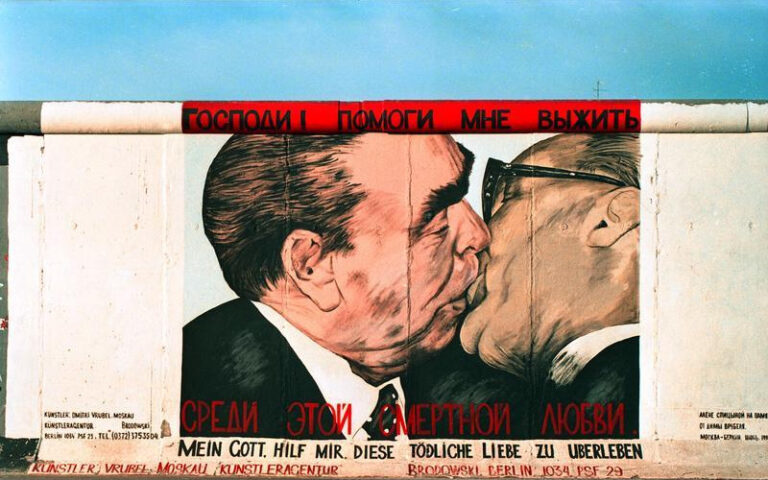 Slavný snímek polibku soudruhů Brežněva a Honeckera, na Berlínské zdi (1989) s komentářem: „Bože, pomoz mi přežít ten polibek smrti“!. FOTO: Bundesarchiv, B 145 Bild-F088809-0038 / {Creator:Joachim F. Thurn/Creative Commons/CC BY-SA 3.0 DE