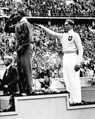 Vyhlášení vítězů skoku do dálky: První je Američan Jesse Owens, německý reprezentant Luz Long zvedá pravici. FOTO: Bundesarchiv Bild / Creative Commons / CC BY-SA 3.0 de