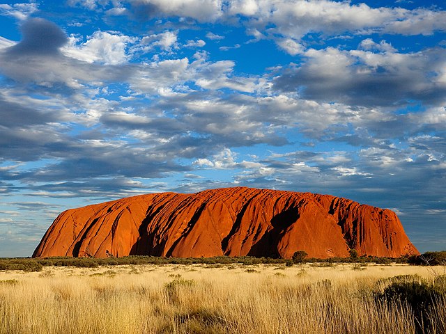 Neobyčejně formovaný a zbarvený monolit Uluru se vypíná v jinak rovinaté krajině.(Foto: Ek2030372672 / commons.wikimedia.org / CC BY-SA 4.0)