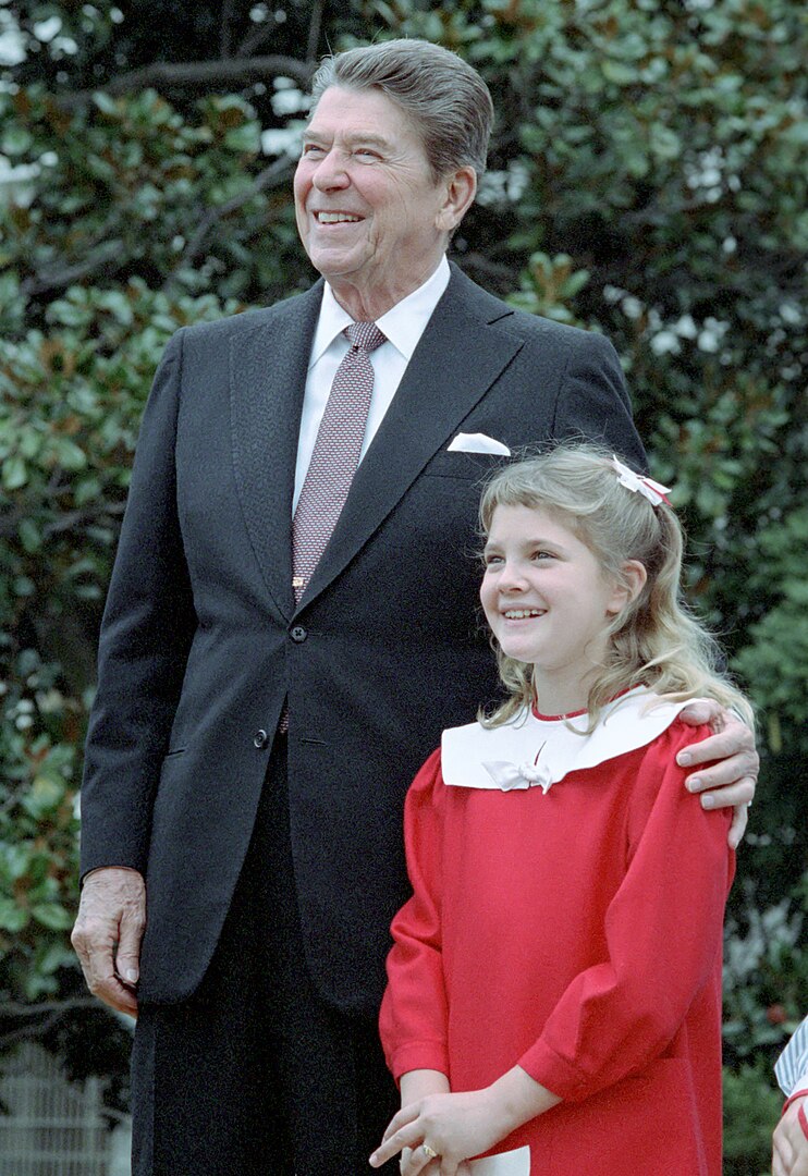 Devítiletá Drew Barrymoreová je taková hvězda, že se s ní chce vyfotit i Ronald Reagan. (volné dílo, commons.wikimedia)