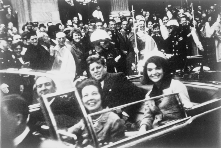 Pár sekund před smrtí JFK sedí vedle manželky.
