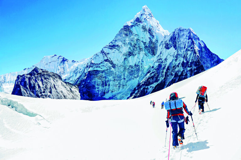 Skupina horolezců dosahující vrcholu Everestu v Nepálu.