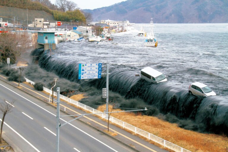 Tsunami v Japonsku (2011) se ve městě Mijako převaluje přes ochranou zeď. Výška vlny zde činila 11,6 m