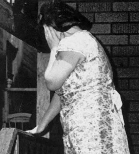 Chumel nic netušících dětí, matka, která odvrací tvář od objektivu, možná v slzách, možná studem.