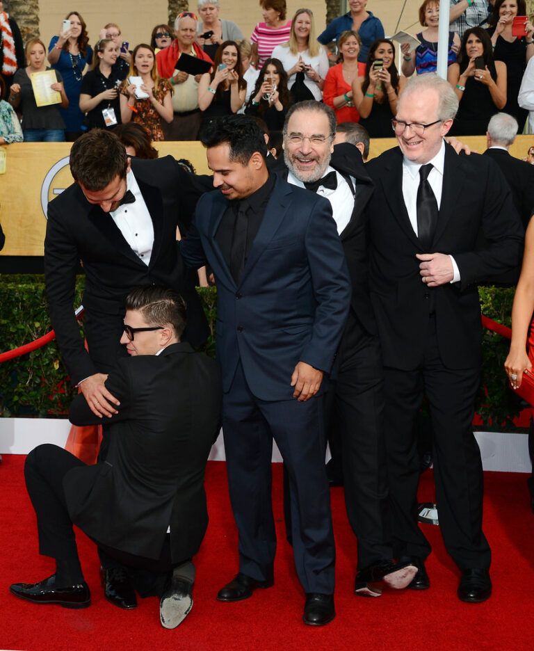 Vitalii Sediuk v momentě, kdy se drží za nohy Bradleyho Coopera na červeném koberci.